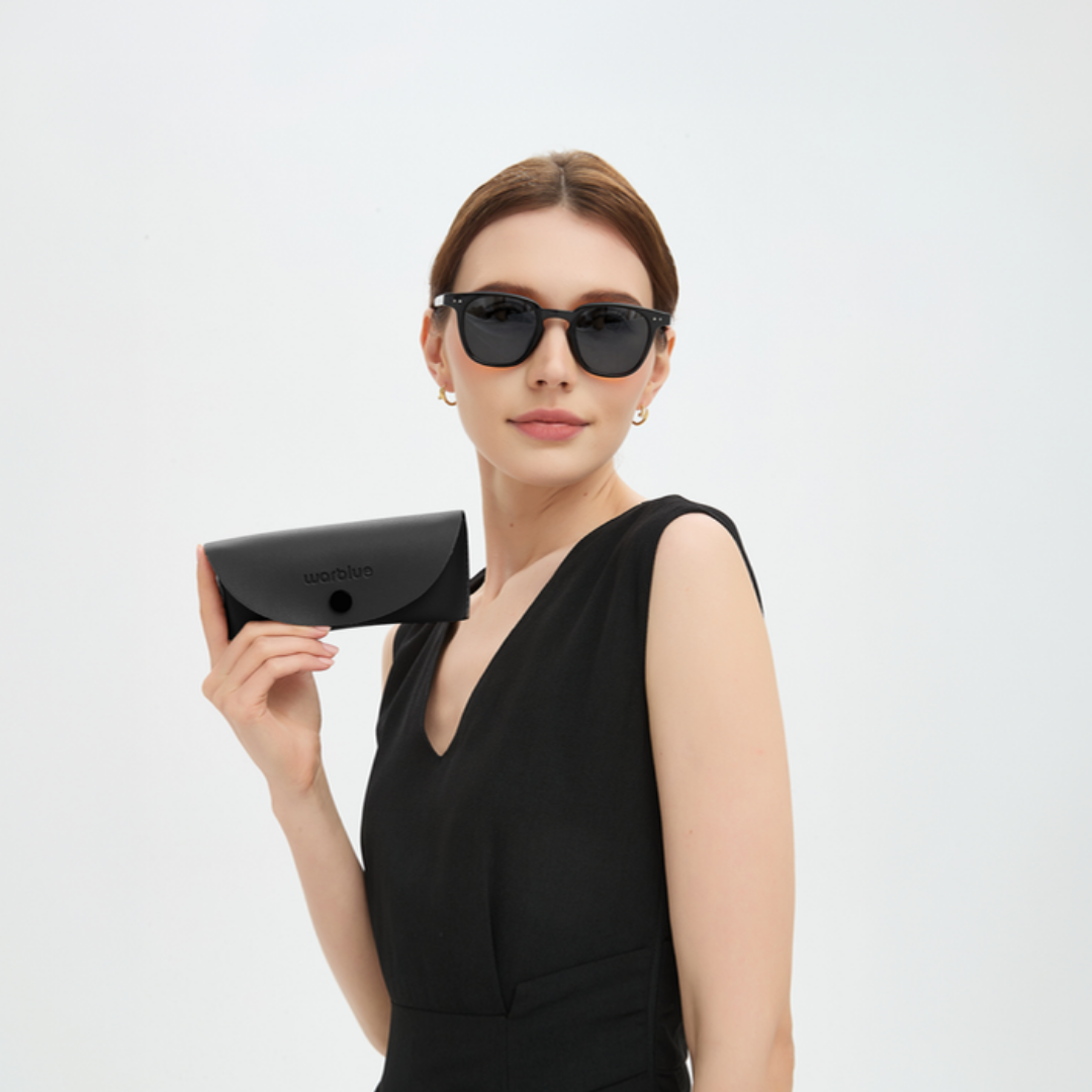 Model hält das Auguste Schutzetui – Sonnenbrille mit schwarzem Gestell